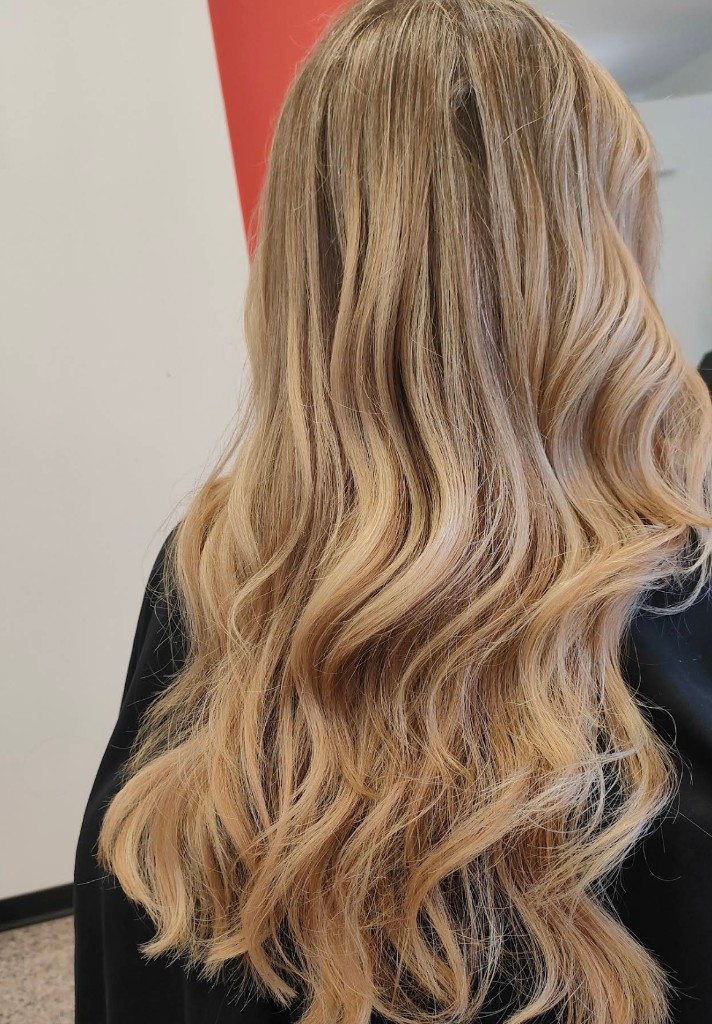Capelli lunghi ondulati dopo servizio di taglio e piega